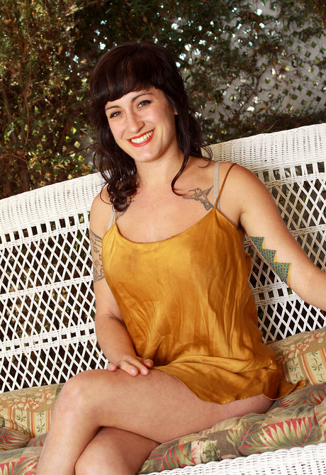 Tattooed brunette Stacey teases her fuzzy monkey outdoors