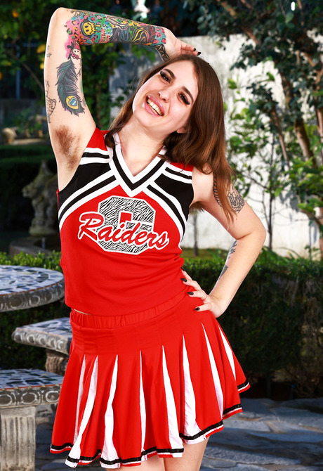 Hairy natural cutie Pearl Sage teasing in cheerleader outfit outdoors