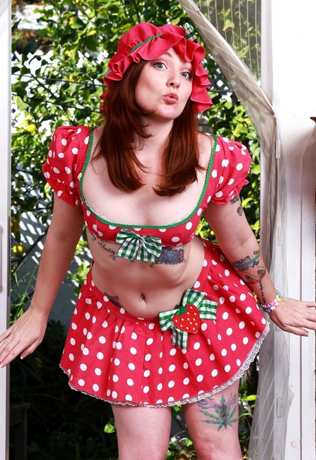 Redhead Kitty Strange strips polka dot outfit to reveal various tattoos and hairy pussy - 1 of 16